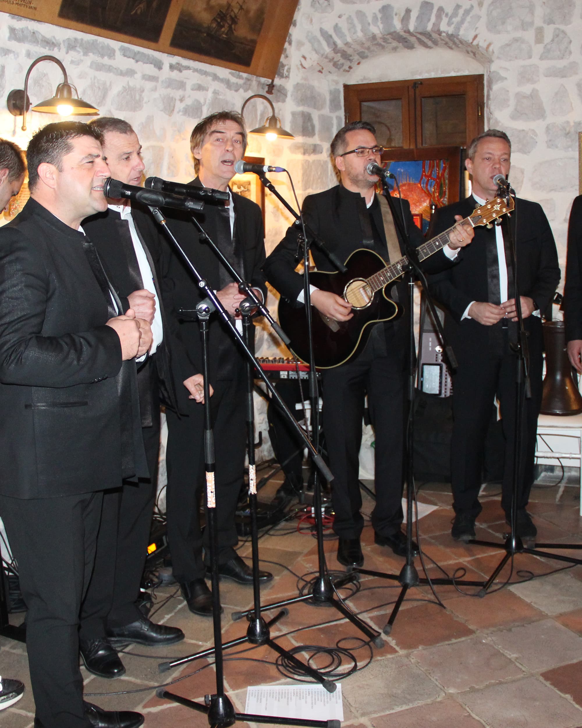 Band performing live at Restaurant Conte, with musicians singing and playing guitar.