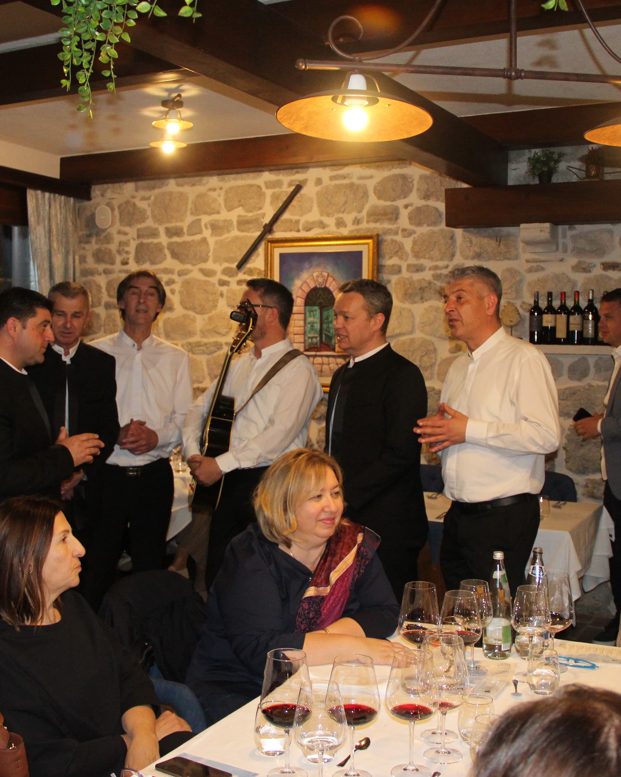 Guests enjoying a live band performance at Restaurant Conte, with musicians and diners in a cozy restaurant setting.