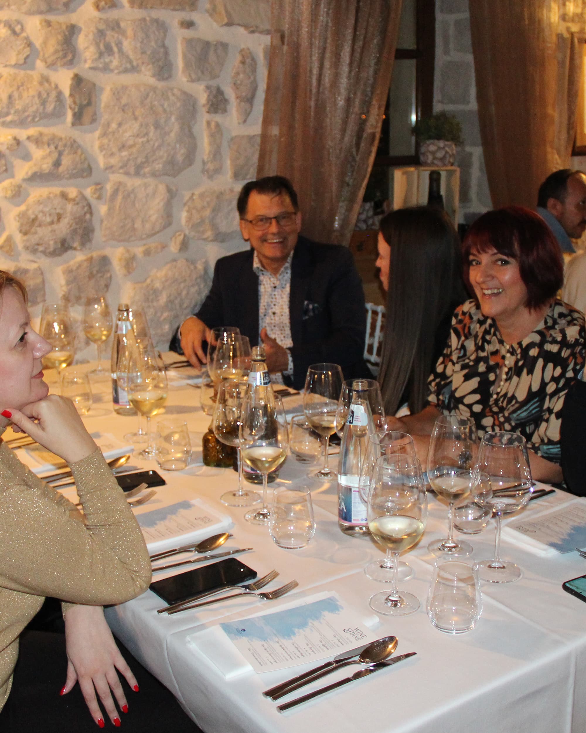 Guests seated around a table, enjoying a meal and conversation at Restaurant Conte.