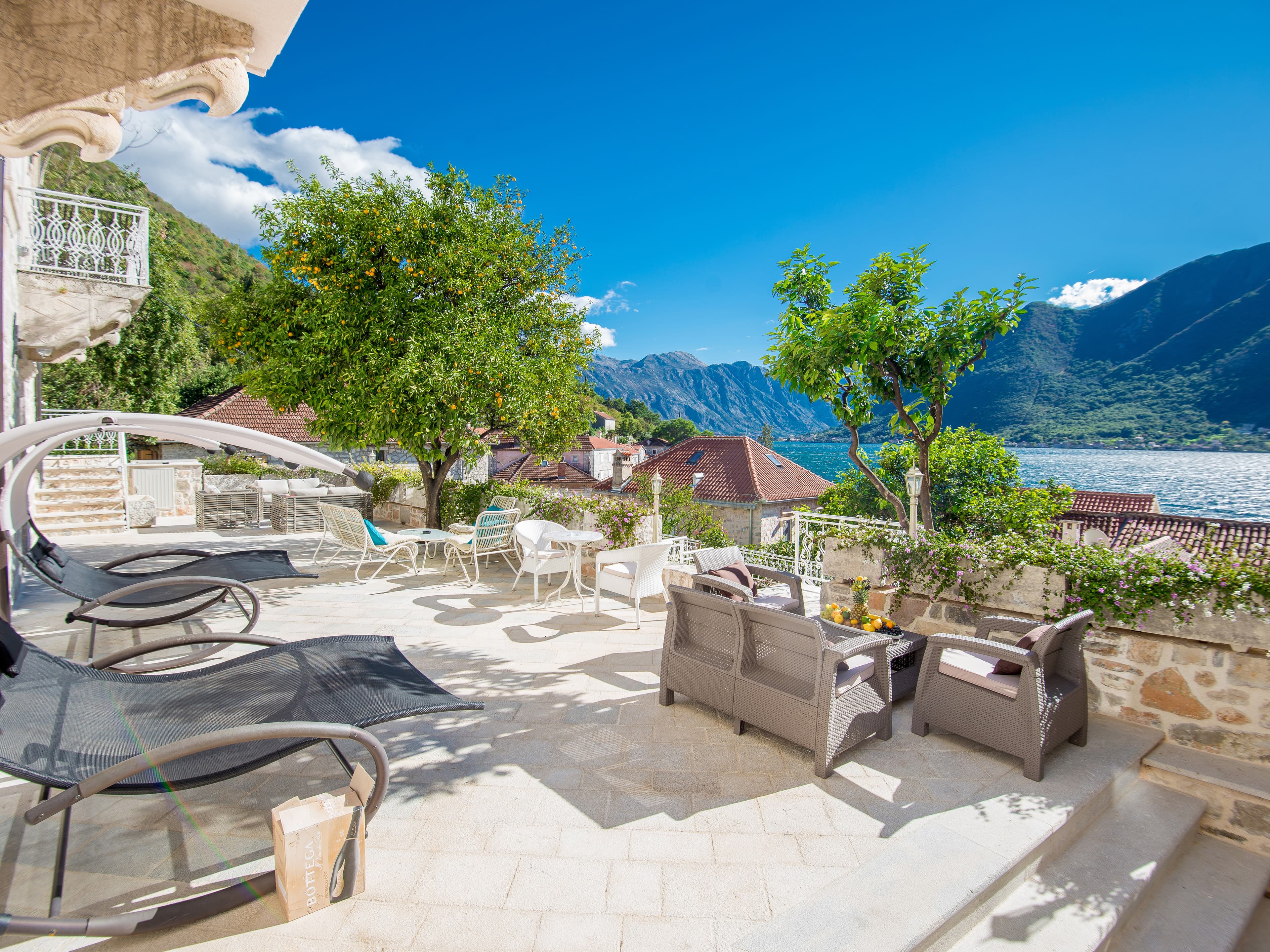 Spacious terrace at Hotel Conte with comfortable seating, sun loungers, and views of the Bay of Kotor and surrounding mountains