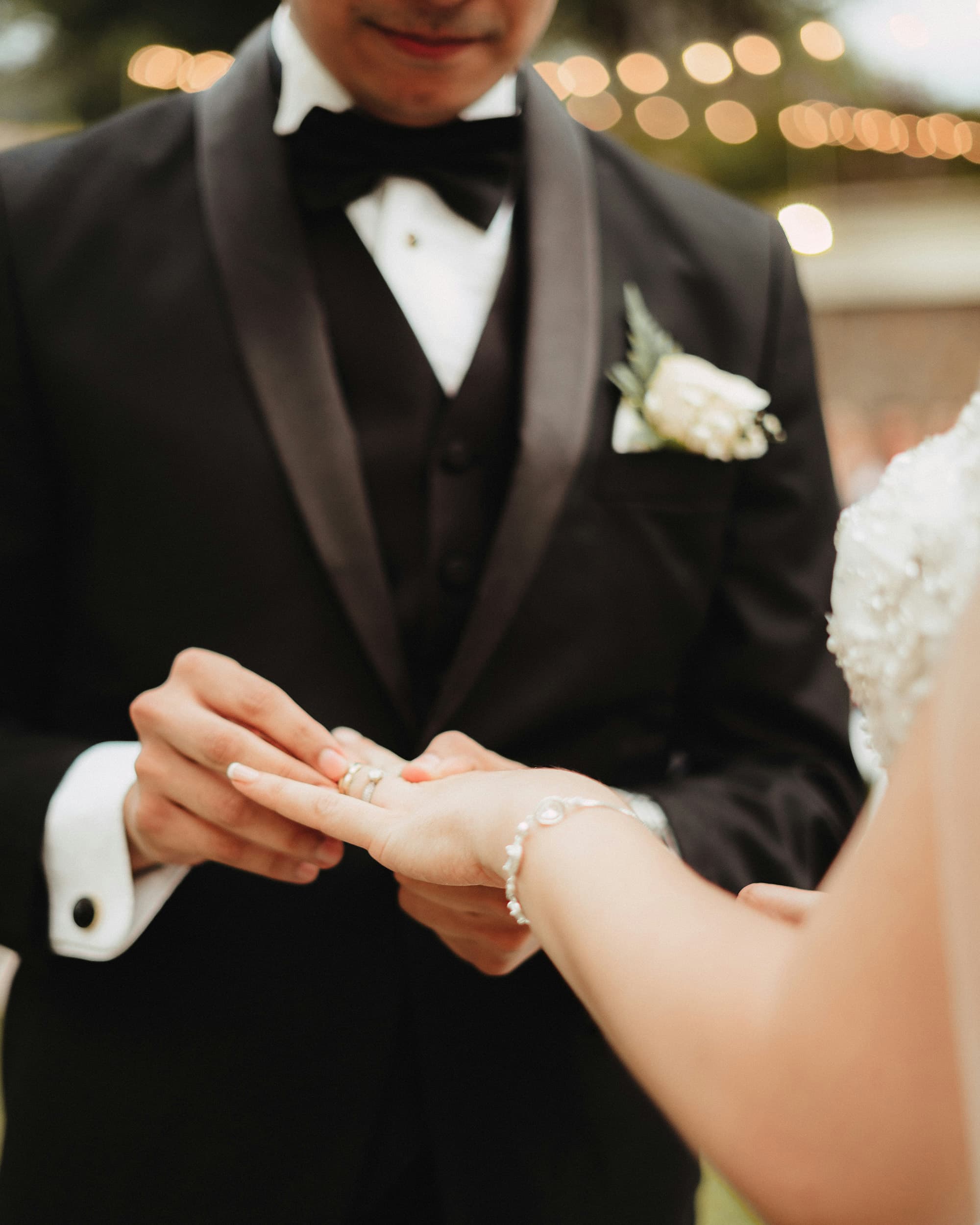 Groom placing a wedding ring on the bride's finger during a ceremony.